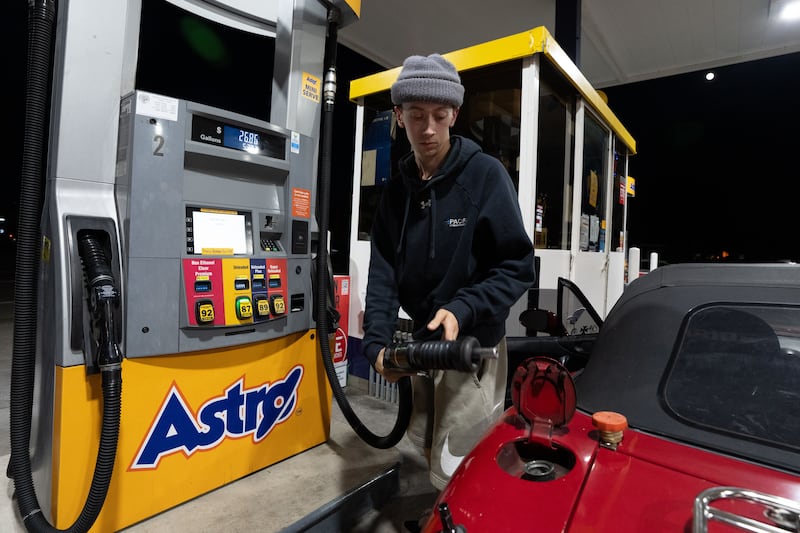 Luciano V. replaces the fuel nozzel after filling the tank of their 1999 Mazda Miata at an Astro gas station on Wednesday, April 29, 2026, in Portland, Ore. (AP Photo/Jenny Kane)