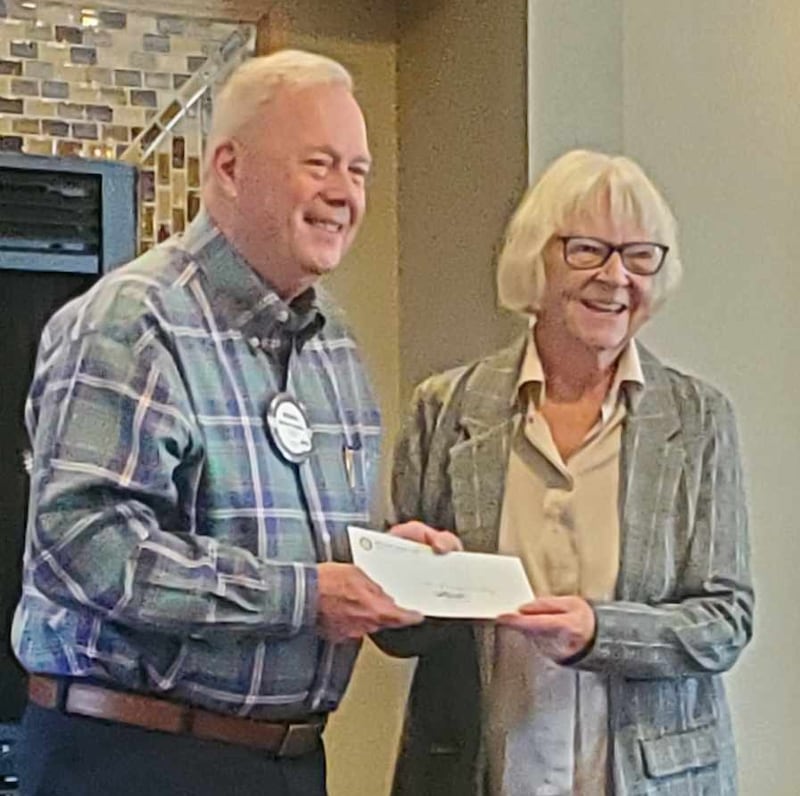 Pictured are Michael Stutkze, Grants Committee member, presenting a check to Sarah Criner representing Open Prairie Church and the Loads of Love laundry program.