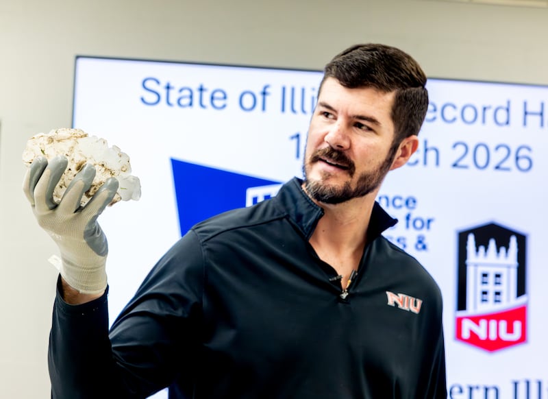 NIU professor and meteorologist Victor Gensini (left) holds a massive hailstone collected from a severe storm in Kankakee County on March 10, 2026. The stone was 6.6 inches wide and weighed nearly 20 ounces, likely a state record once certified, according to NIU.