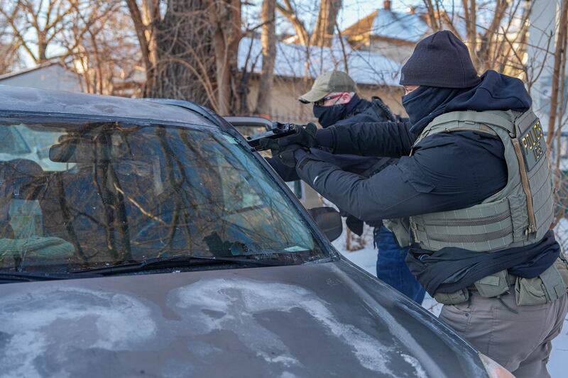 Activists are approached by a federal agent brandishing a firearm, for following agent vehicles, on Tuesday, Feb. 3, 2026, in Minneapolis. (AP Photo/Ryan Murphy)