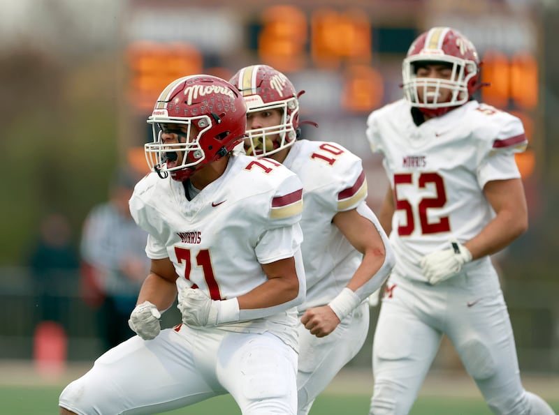Morris' Bryce Lee (71) and his teammates Owen Olson (10) and Chace Bachert (52) celebrate during the IHSA Class 4A semifinals football playoff game Saturday, Nov. 22, 2025 in Lombard.