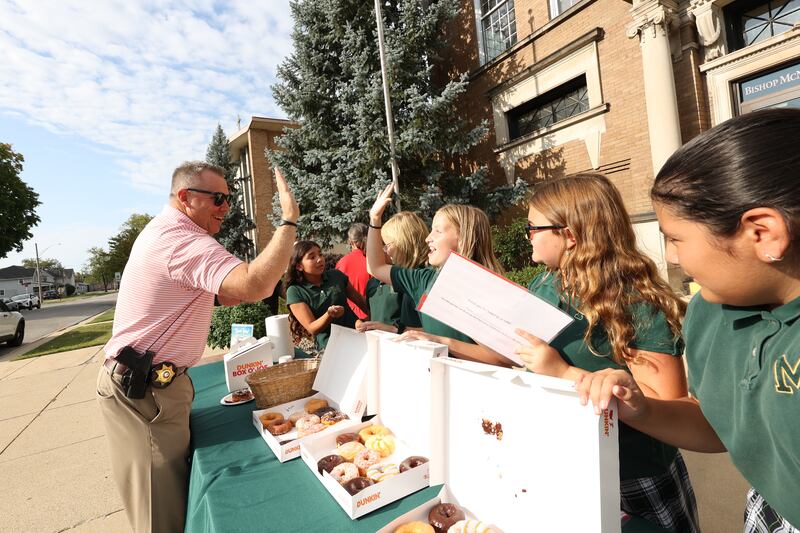 Kankakee County Undersheriff Chad Gessner high fives Bishop McNamara Catholic School fifth graders, all members of the student council, as they host the 10th Gratitude Drive-Thru for first responders and military members on Thursday, Sept. 11, 2025. The school hosts the event at all three sites each year on the anniversary of the tragic events of Sept. 11, 2001.