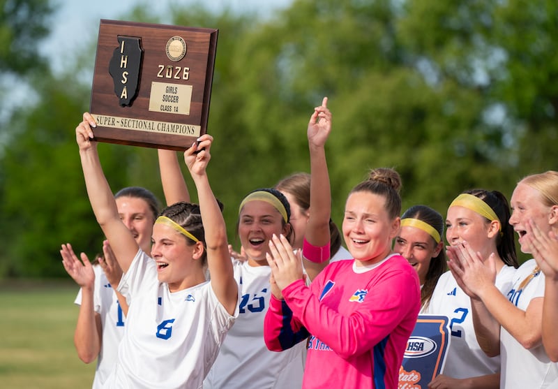 Johnsburg's Liz Smith (6) holds up the Supersectional trophy with teammates after defeating Rockford Christian during the girls soccer Class 1A Marian Central Supersectional on Monday, June 1, 2026 at Marian Central Catholic High School in Woodstock. Ryan Rayburn for Shaw Local