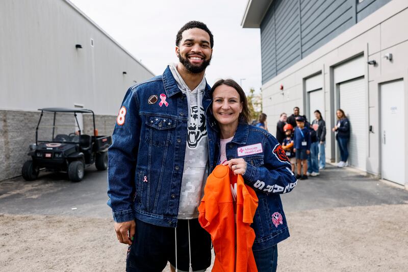 Amy Cash of Volo (right) poses with Bears quarterback Caleb Williams. Cash is holding a signed jersey that Williams gave to her.