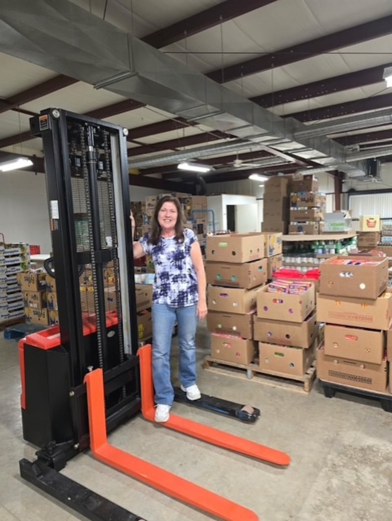 Mary Jo Credi, executive director of the Illinois Valley Food Pantry, shows off the pantry’s new electric pallet stacker, funded with an anonymous donation of more than $12,000.