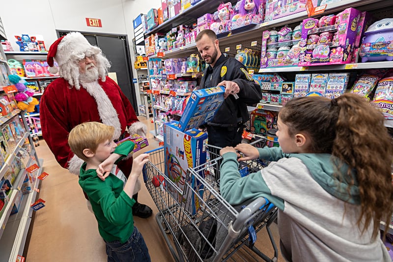 Santa, Dixon officer Ryan Bivins and daughter Marley, 10, help Owen Wilhite, 7, pick out gifts Saturday, Dec. 9, 2023 at Dixon Walmart.