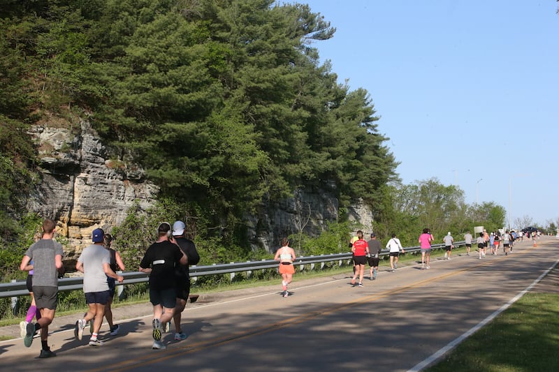 Runners pass by the entrance to Starved Rock State Park in the Starved Rock Country half-marathon on Saturday, May 10, 2025 at Starved Rock State Park.