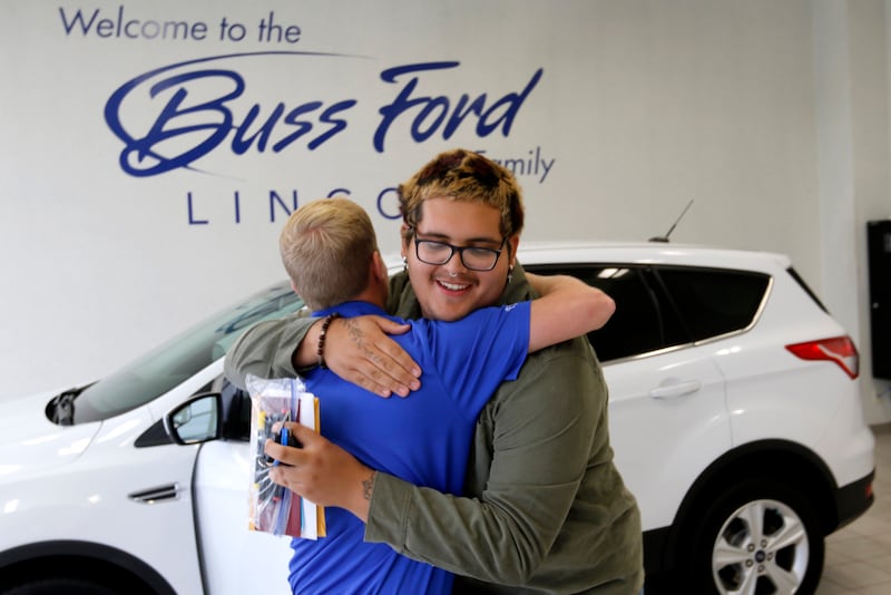 Daniel Avila hugs Drew Buss of Buss Ford on Wednesday, June 18, 2025, at the dealership in McHenry while picking up his car. Avila's teacher, Kate Knaack, created a GoFundMe to help the 2025 McHenry High School graduate buy a car, allowing him to go to McHenry County College this fall, work this summer, and help his dad care for his 8-year-old twin brothers following his mother's death in February 2024.