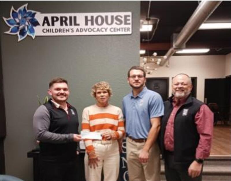 Carrie Melton of April House Children's Advocacy Center (second from left) accepts a donation from Whiteside County Bar Association members (from left) Maverik Good, Ryan Olson and Trent Bush.