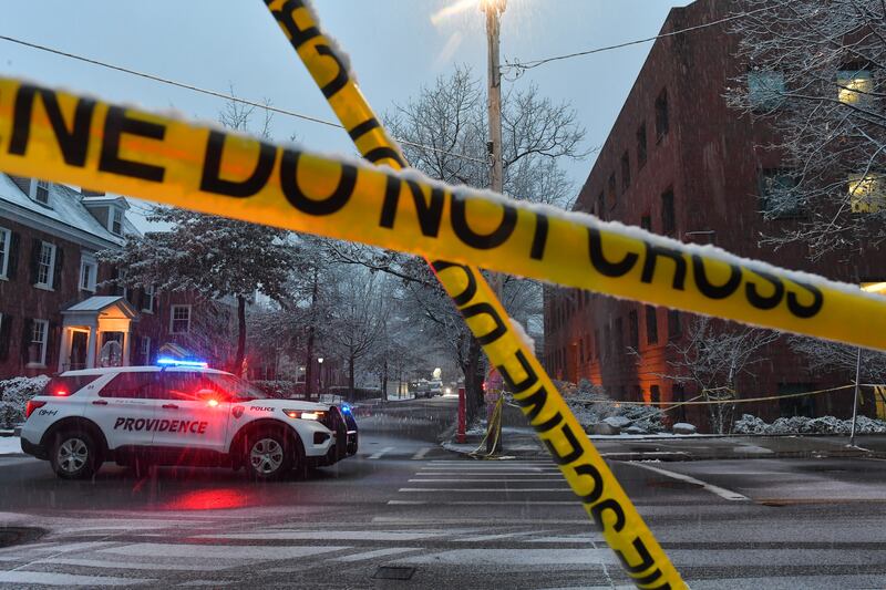A police vehicle rests at an intersection near crime scene tape at Brown University, Sunday, Dec. 14, 2025, in Providence, R.I., following a Saturday, Dec. 13, 2025 shooting at the university. (AP Photo/Steven Senne)