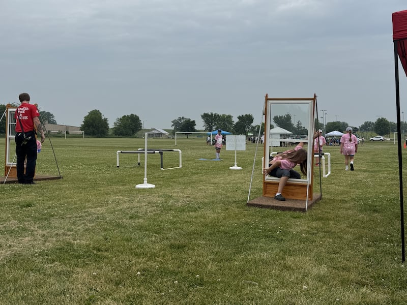 A Camp 911 student runs the Morris Fire Department's obstacle course, which shows kids to stop, drop and roll, how to climb through a window, how to dial 911, and how to pull a fire alarm on Friday, June 13, 2025.