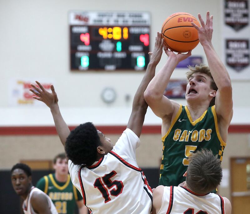 Crystal Lake South's Carson Trivellini (center) shoots the ball over Huntley's Isaac Muze (left) and Tyler Dudzinski (right) during a Fox Valley Conference boys basketball game on Wednesday, Dec. 10, 2025, at Huntley High School.