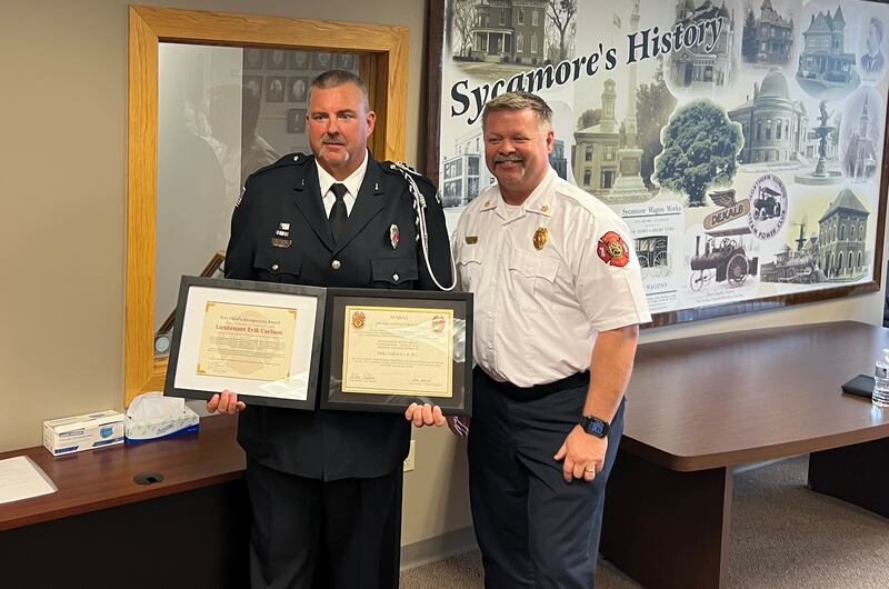 Sycamore firefighter, Lieutenant Erik Carlson, stands next to Sycamore Fire Chief Bart Gilmore after being presented with two awards at a Sycamore City Council meeting on Sept. 2, 2025.