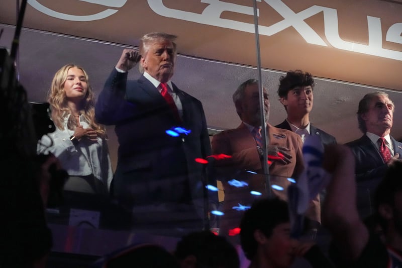 President Donald Trump gestures during the National Anthem as he attends an NBA Finals playoff basketball game between the New York Knicks and the San Antonio Spurs at Madison Square Garden in New York, Monday, June 8, 2026, with Kai Trump, left, Knicks owner James Dolan and Interior Secretary Doug Burgum, right. (AP Photo/Mark Schiefelbein)