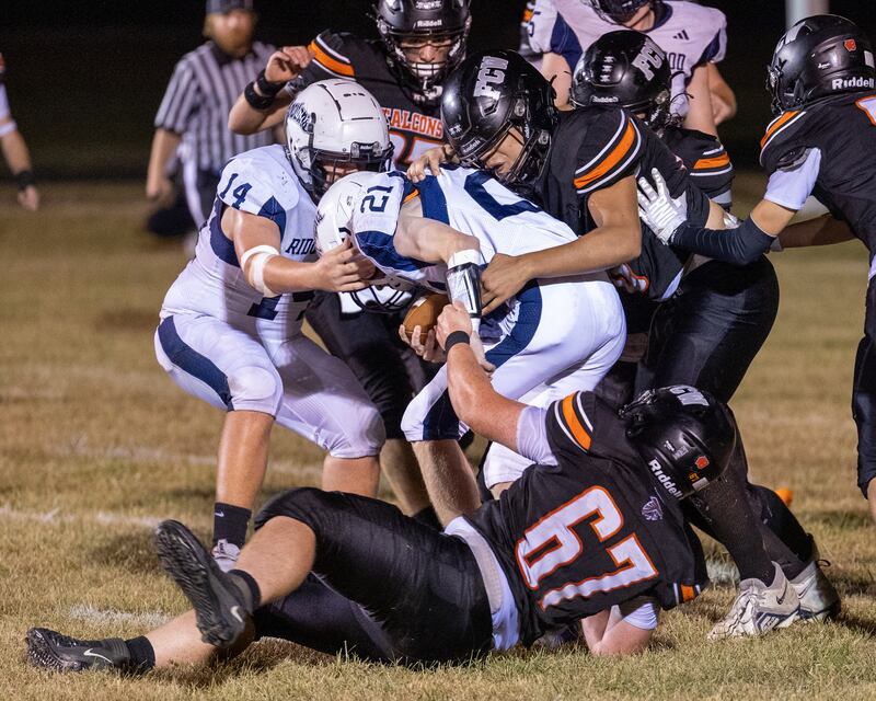 Carson Hancock (21) of Ridgewood is held by FCW defense on Friday, Sept. 26, 2025, at Woodland School in rural Streator.