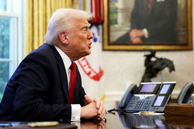 President Donald Trump speaks to reporters in the Oval Office at the White House in Washington.