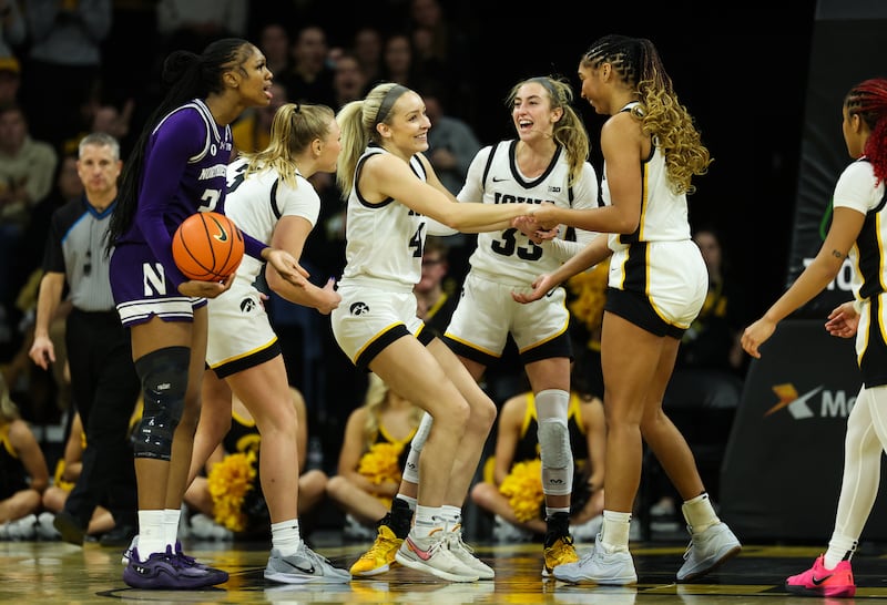 Iowa Hawkeyes guard Kylie Feuerbach (4) is congratulated by teammates Sydney Affolter (3), Lucy Olsen (33) and Hannah Stuelke after drawing a charge against the Northwestern Wildcats Tuesday, January 28, 2025 at Carver-Hawkeye Arena. (Brian Ray/hawkeyesports.com)