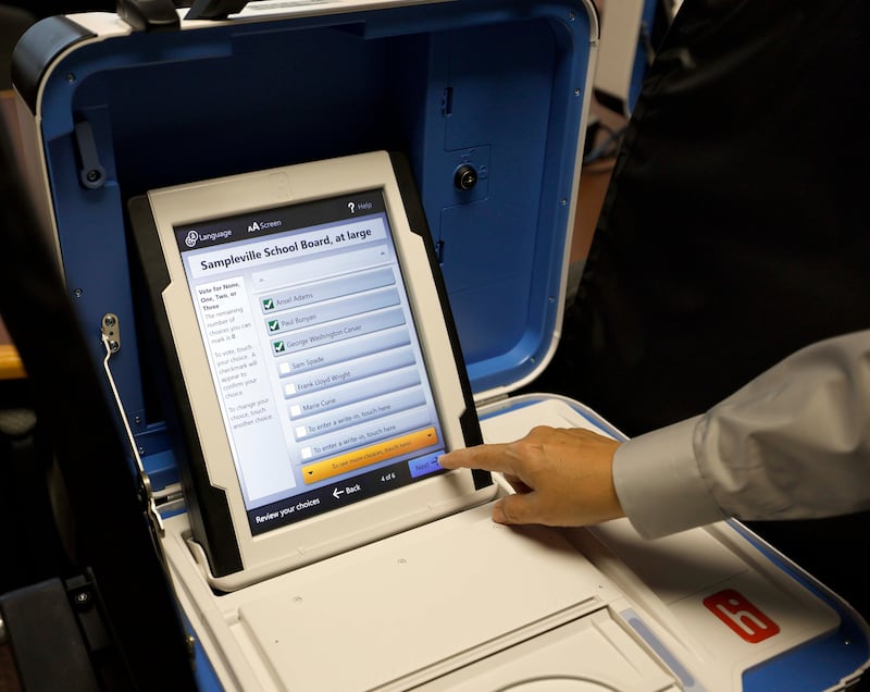 Director Of Elections at Kane County Clerk's Office Raymond Esquivel demonstrates how to vote on a sample ballet as they set up for early voting machines Tuesday, Sept. 24, 2024 in Geneva.