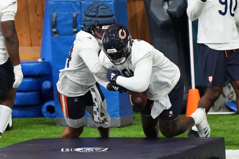 Chicago Bears defensive lines Austin Booker, left, works with Gervon Dexter Sr. during NFL football practice in Lake Forest, Ill., Wednesday, May 21, 2025. (AP Photo/Nam Y. Huh)