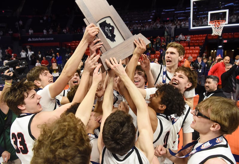 Benet Academy players celebrate with their state championship trophy at the conclusion of the IHSA Class 4A boys basketball state championship game against Warren at State Farm Center on Saturday, March 15, 2025 in Champaign.