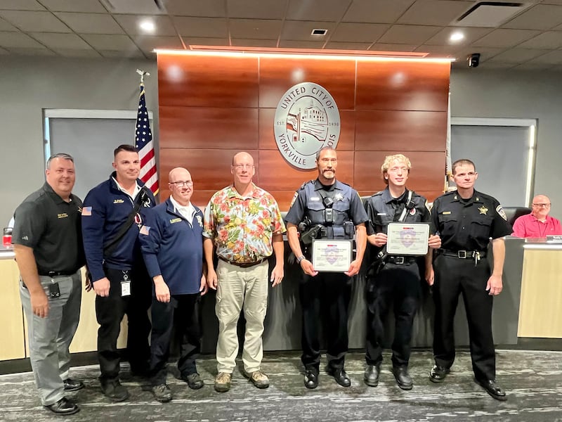 Members of the Yorkville Police Department and the Bristol Kendall Fire Protection District, join Mayor John Purcell is presenting "Lifesaving Awards" to Officer Tim Kolowski (third to right) and Bristol Kendall fireman Kaleb Dhuse (second to right) at the Aug. 26 city council meeting at City Hall.