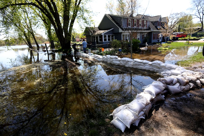 Volunteers work to protect a home in Holiday Hills  as flooding continues on the Fox River on Wednesday, April 22, 2026.