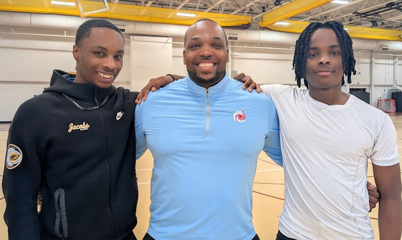 Marian Central boys basketball coach Lafeyette Bell is flanked by his sons Elijah (left) and Malachi (right) after Jacobs beat Marian Central 57-48 in a nonconference game Saturday, Jan. 10, 2026, in Algonquin. Elijah and Malachi Bell play for Jacobs.