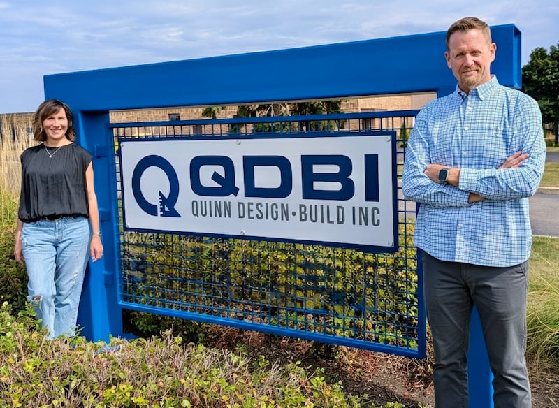 Quinn Design-Build Inc. owners Nancy Quinn, vice president, and Ryan Quinn, president, pose with the company’s new sign outside QDBI’s St. Charles offices.