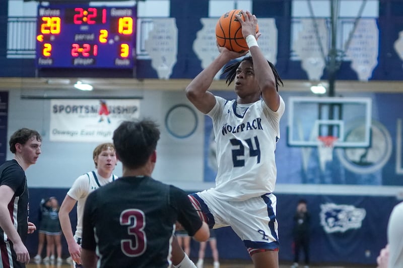Oswego East's Mason Lockett IV (24) shoots the ball against Plainfield North's Lukas Alvarez (3) during a basketball game at Oswego East High School on Friday, Dec. 6, 2024.