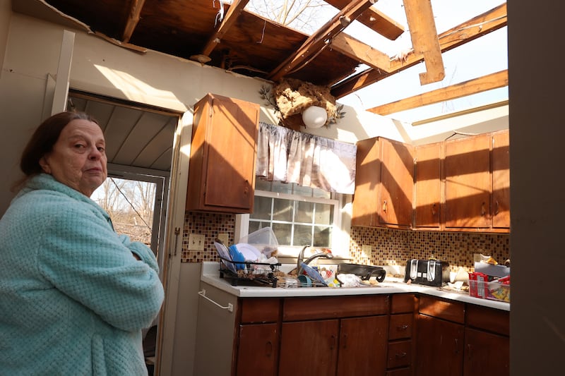 Aroma Park resident Patricia Kime recounts the damage to the kitchen of her home on Strasma North Drive, which was destroyed by the March 10 EF-3 tornado. The bathroom she took shelter in was the only intact room in the house, she said.