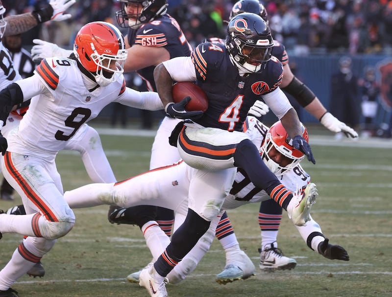 Chicago Bears running back D'Andre Swift highsteps past two Cleveland Brown defenders on his way to the endzone during their game Sunday, Dec. 14, 2025, at Soldier Field in Chicago.
