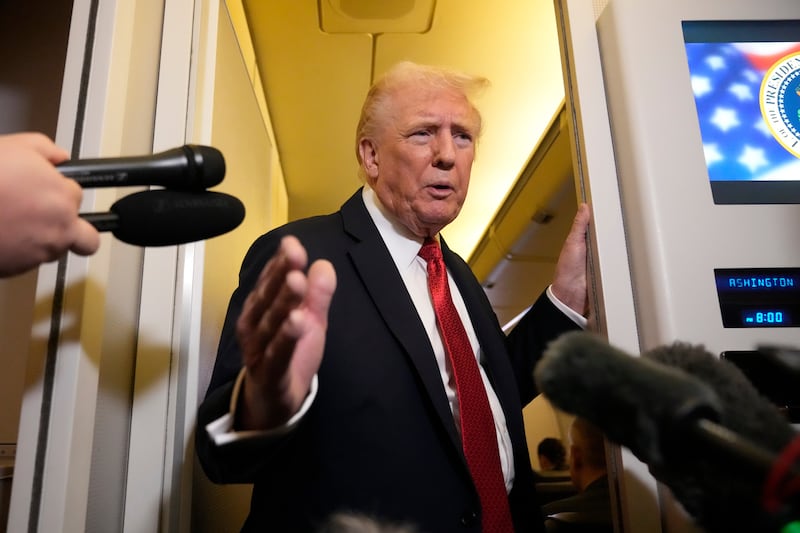 President Donald Trump speaks to reporters aboard Air Force One, Sunday, Oct. 19, 2025, en route to Joint Base Andrews, Md., as he returns from a trip to Florida. (AP Photo/Mark Schiefelbein)
