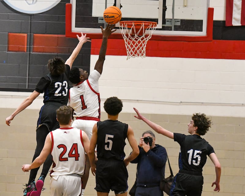 Glenbard East's Keenan House (1) makes a basket while being defended by Riverside Brookfield's Noah Van Tholen (23) during the game on Friday Dec. 19, 2025, held at Glenbard East High School.