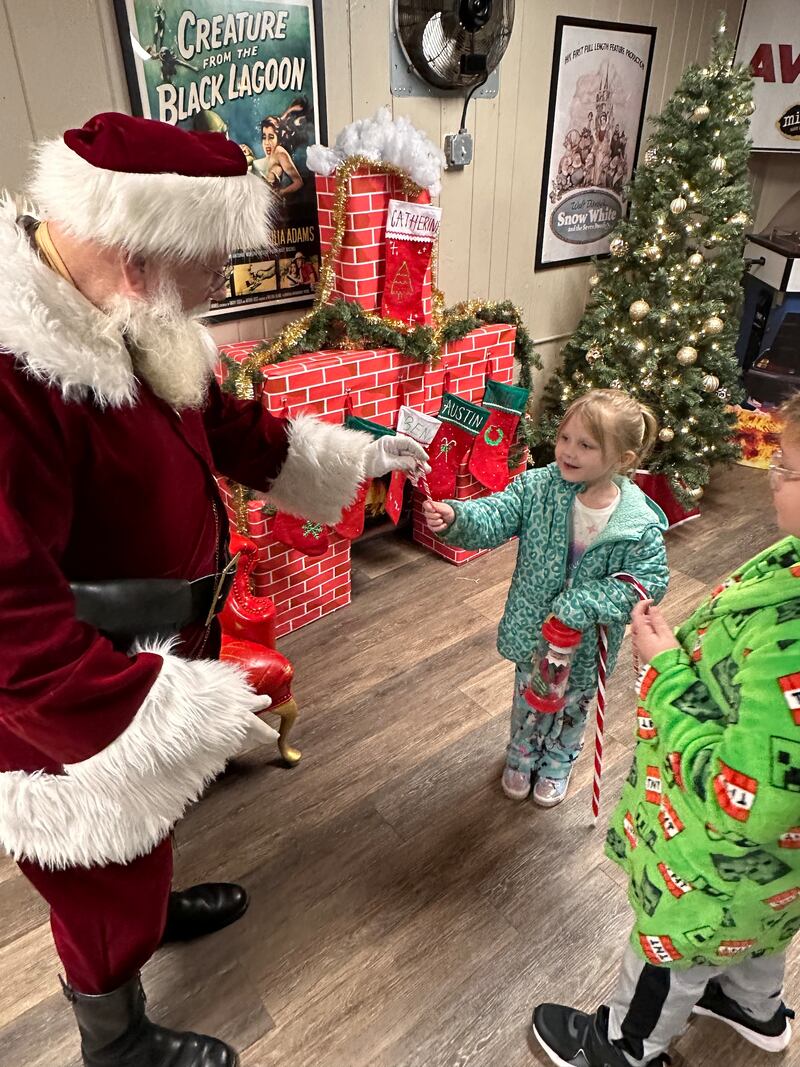 Danika Plancon of McHenry receives a candy cane from Santa as her brother, Donovan, looks on at the McHenry Outdoor Theater, where movies are scheduled until late December. A toy drive takes place Dec. 5-6, with a Santa sighting expected on Dec. 6.