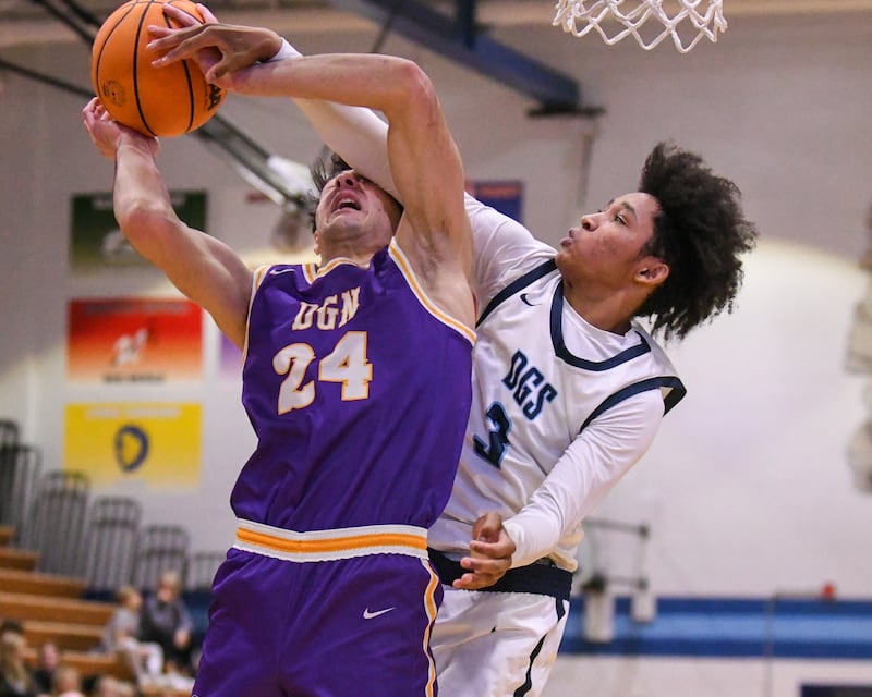 Downers Grove North's Aidan Akkawi (24) makes a basket while being fouled by Downers Grove South's Adam Flowers (3) during the game on Saturday Dec. 21, 2024, held at Downers Grove South High School.