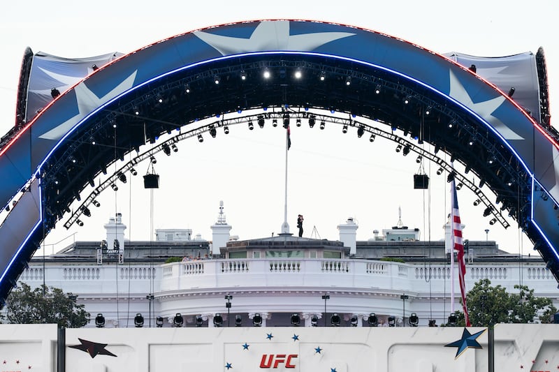FILE - Security at the White House looks through a pair of binoculars during the UFC Fan Fest on the White House Ellipse ahead of Sunday's fight on the South Lawn, June 13, 2026, in Washington. (AP Photo/Allison Robbert, File)