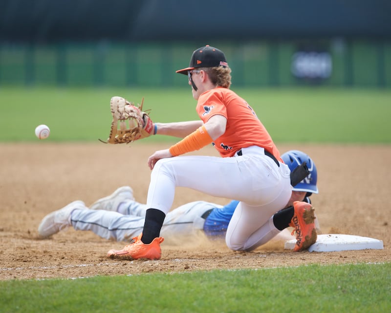 St. Charles East's Joey Arens waits for the pick off throw as St. Charles North's Keaton Reinke slides back safely on Saturday April 27, 2024 in St. Charles.