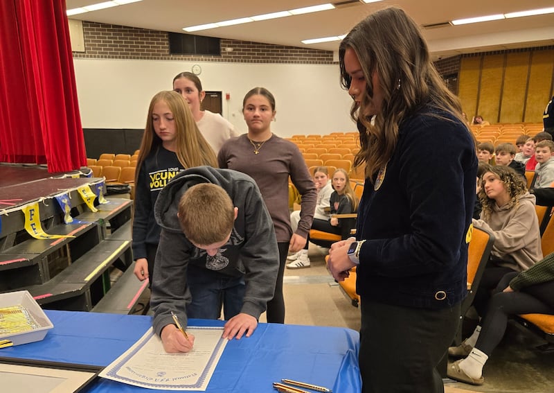 Illinois Association FFA State President Natalie Pratt (right), an Amboy FFA Alumni, oversees the student signing of the middle school Amboy FFA charter Nov. 10, 2025.