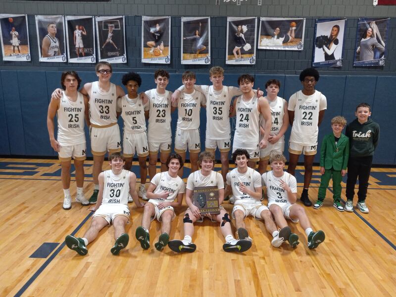 The Bishop McNamara boys basketball team poses under the basket after winning the IHSA Class 2A Fieldcrest Regional on Friday, Feb. 28.