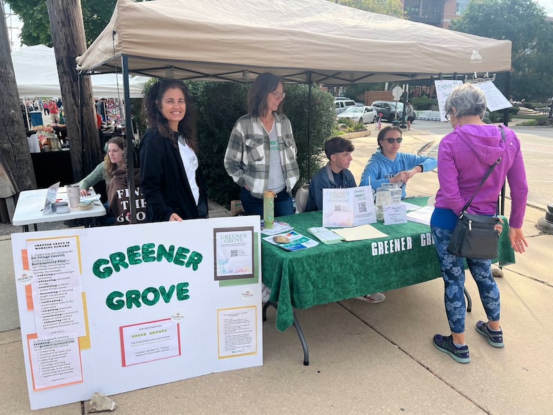 Members of Greener Grove work their booth at the village's Farmer's Market