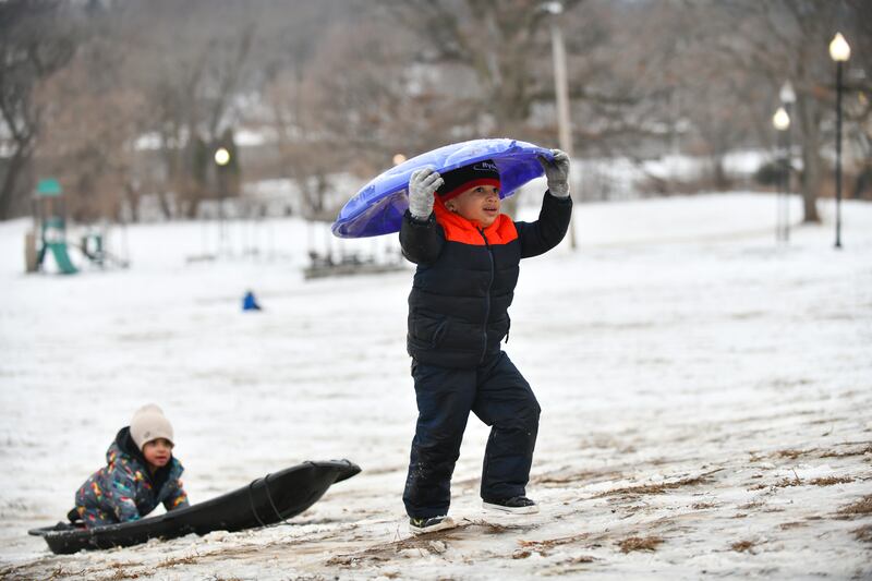 Elijah Ford, 4, of Momence, uses his head to carry his sled back up the hill at Helgeson Park in Bradley on Saturday, Feb. 15, 2025.
