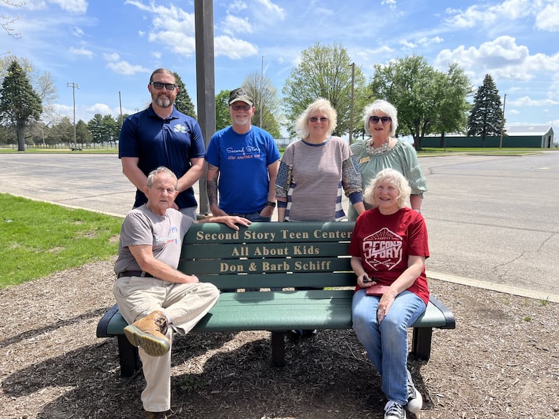 Don and Barb Schiff are pictured seated on their donated bench at the Zearing Park playground, celebrating the spirit of community and the joy of the outdoors. Back row: Nick Davis, Assistant Director, Princeton Park District, Jeff & Dana VanAutreve, Second Story Teen Center & Tammy Lange, Executive Director, Princeton Park District