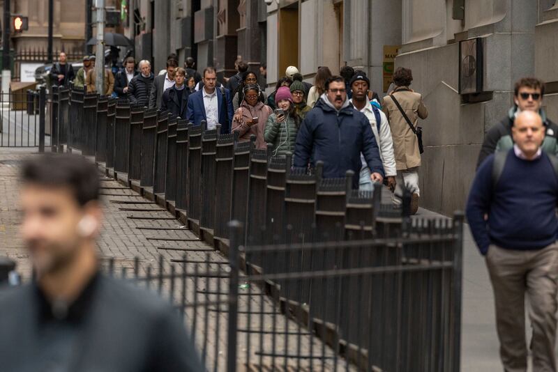 FILE - Commuters walk past the New York Stock Exchange, April 8, 2025, in New York. (AP Photo/Yuki Iwamura, File)