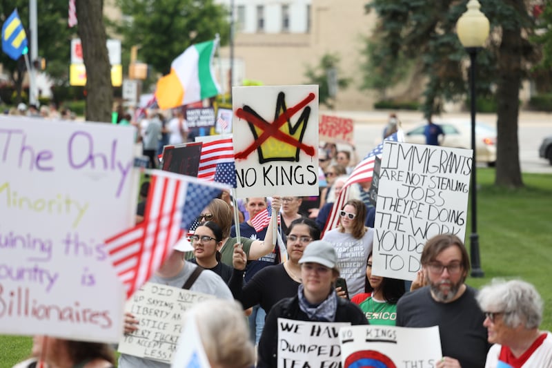 Protesters carry signs as approximately 500 people gathered at the Kankakee County Courthouse for a ‘No Kings’ rally in Kankakee on Saturday, June 14, 2025, to protest actions by President Donald Trump.