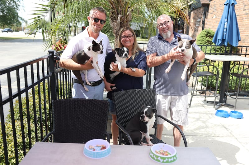 Brent Stary and his wife Tracy, owner of McBride’s on 52, along with General Manager Sean Mahoney poses for a photo with their boston terriers on Wednesday, August 21, 2024 in Joliet.
