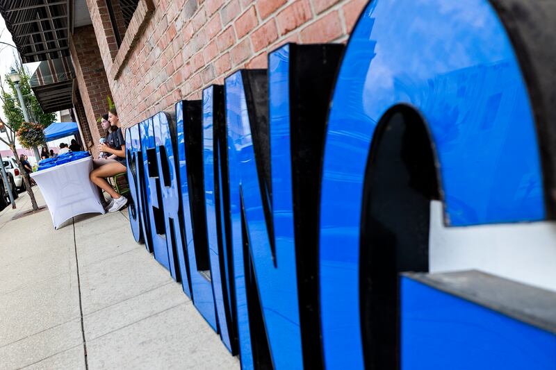 Camryn Wheat (left) and Kate VonHolten of the SVCC Impact program sell T-shirts outside of the Sterling Main Street office Friday, Aug. 1, 2025, during Hot Dog Day.