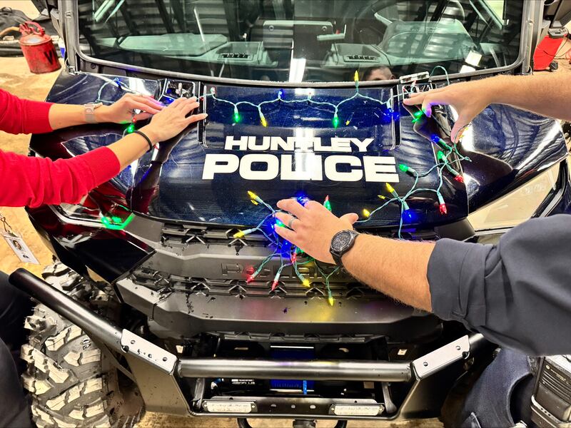Carly Ritter and Officer Jerry Keppler from the Huntley Police Department decorate department vehicles Wednesday, Dec. 3, 2025, for Saturday's Christmas parade, a newly added part of the Very Merry Huntley holiday celebration. The parade steps off at 5 p.m. Saturday at the intersection of Main and Bakley streets.