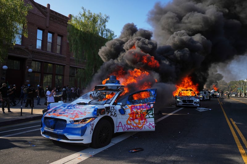 Multiple Waymo taxis burn near the Metropolitan Detention Center of downtown Los Angeles, Sunday, June 8, 2025, following last night's immigration raid protest. (AP Photo/Eric Thayer)