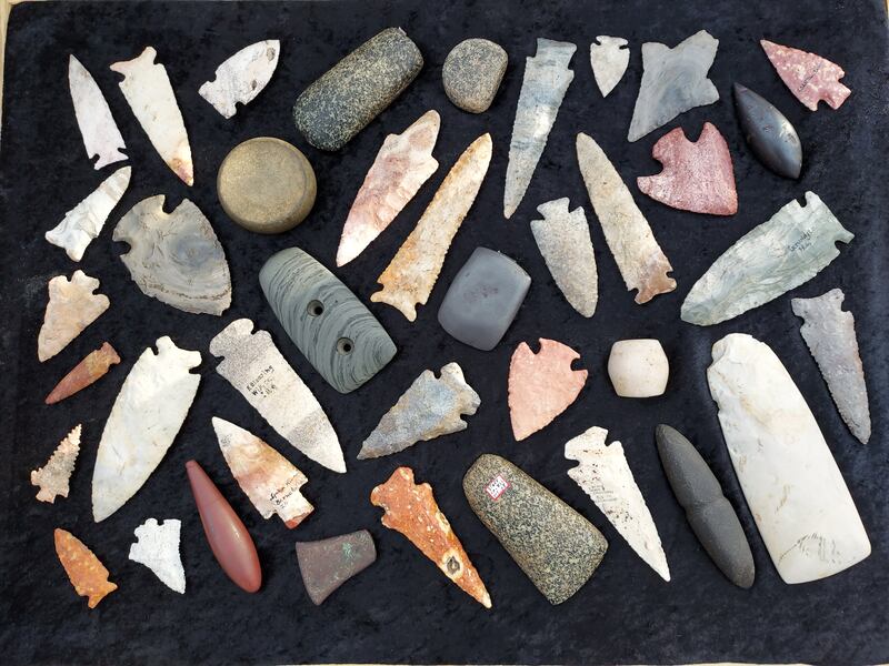 Tristen Arnold, president of the Illinois State Archaeological Society, displays his prehistoric Native American artifacts, such as flint projectile points, stone tools, and ornamental pieces.