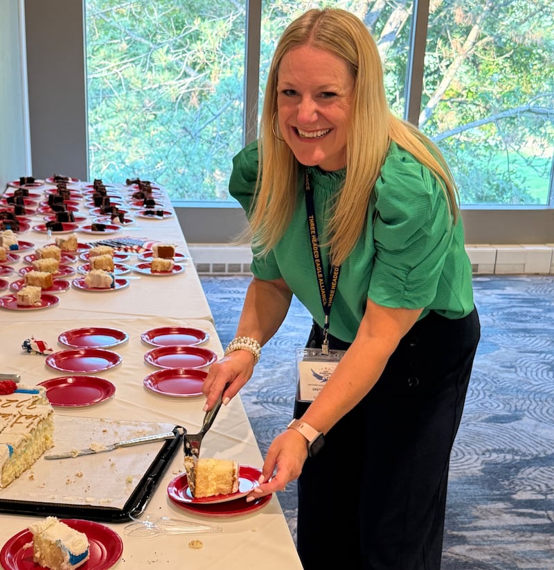 Three Headed Eagle Alliance Chair Gretchen Butler serves cake to celebrate the Geneva conservative group's fifth year at the June 10, 2025 meeting at the Eagle Brook Country Club in Geneva.